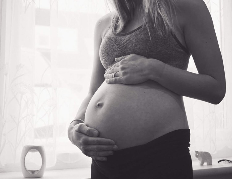 Sinead pregnant in her studio and holding her bump