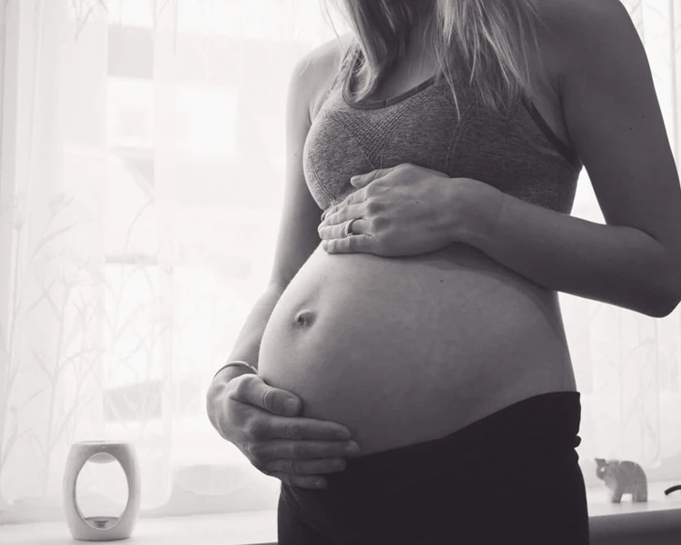Sinead pregnant in her studio and holding her bump
