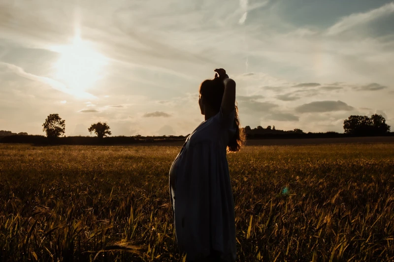 Pregnant woman by a sunset